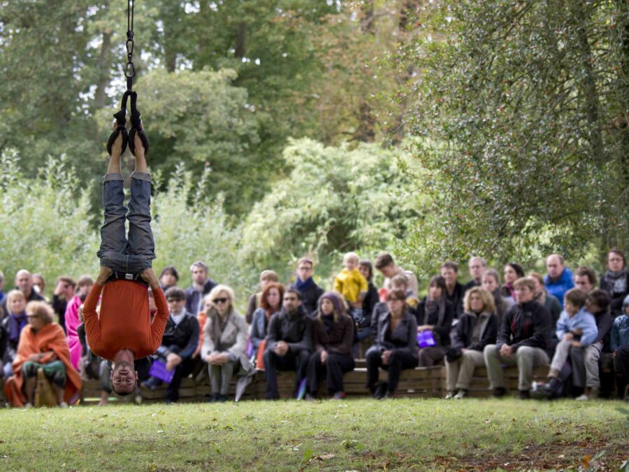 Ève Magot danse suspendue par les pieds dans le solo La 36ème Chambre lors du Festival Plastique Danse Flore, Versailles